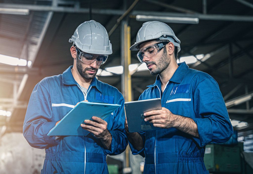 Inspector engineers looking at the document clipboard. Routine maintenance inspection checklist.